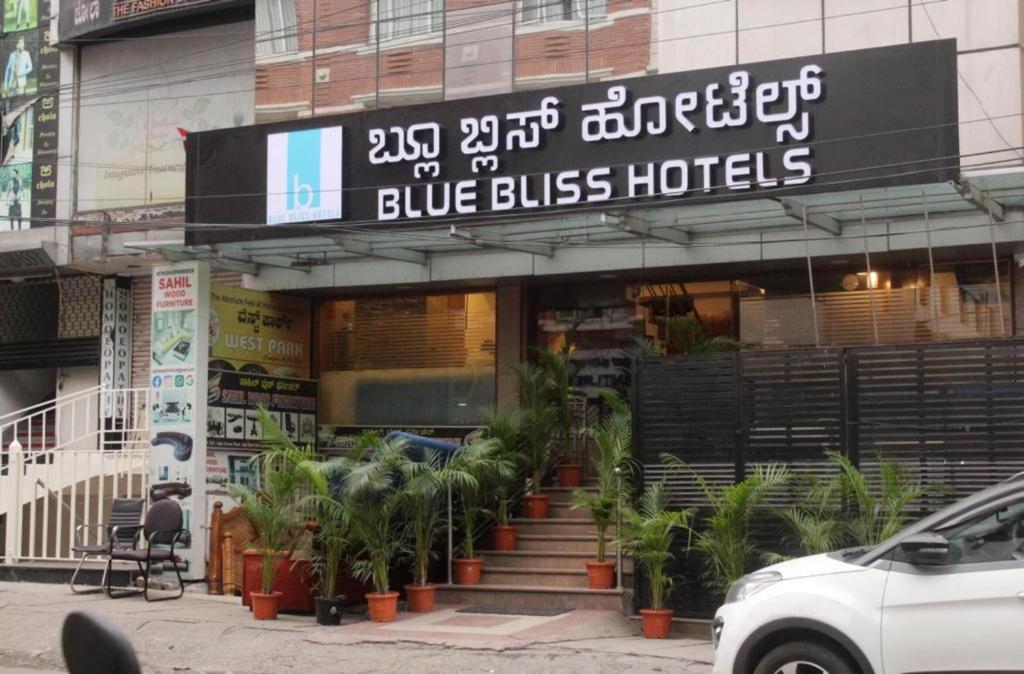 Blue Bliss Hotel By PPH Living في بانغالور: فندق باص ازرق وامامه نباتات