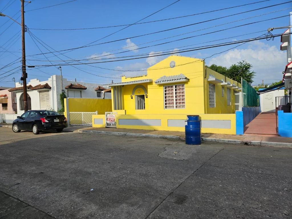 un edificio amarillo al lado de una calle en Beach Getaway with Cozy 2 Bedrooms near the Ocean, Arecibo, en Arecibo