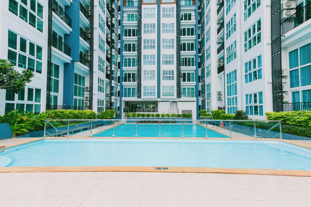 an empty swimming pool in a building with tall buildings at The Prio Condo in Chiang Mai