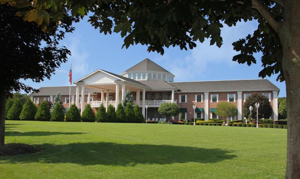 a large building with a lawn in front of it at The Inn and Spa at East Wind in Wading River