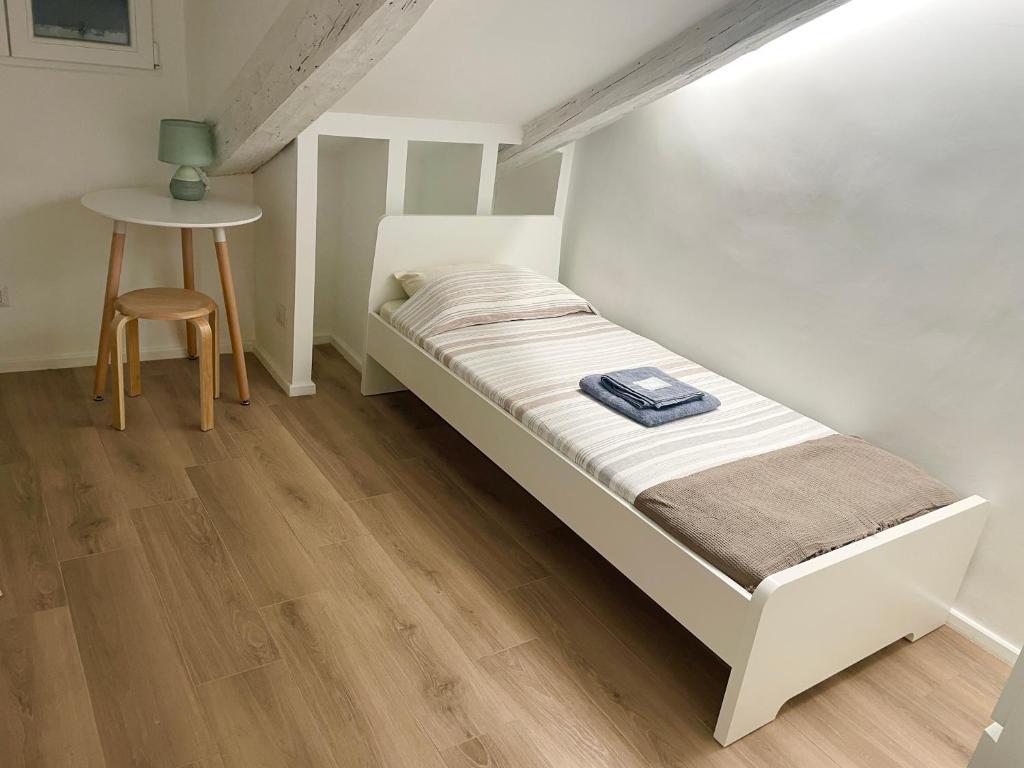 a bed in a room with a table and a stool at Mansarda (B13) Belfiore in Turin