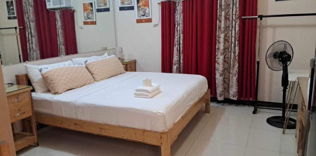 een slaapkamer met een groot bed met rode gordijnen bij 101 NB Ziah accomodation place in Manilla
