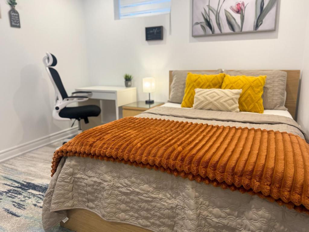 a bedroom with a bed with an orange blanket and a desk at Whitby Private Rooms in Whitby