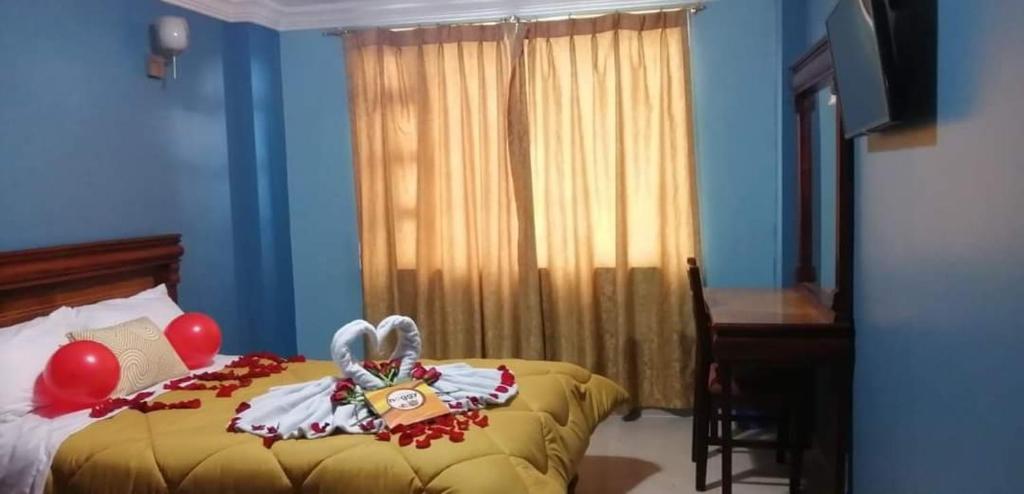 - une chambre avec un lit avec des ballons et un bureau dans l'établissement Hostal zamorano, à Quito