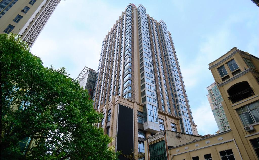 um edifício alto no meio de alguns edifícios em Guangzhou Uhome Service Apartment em Guangzhou