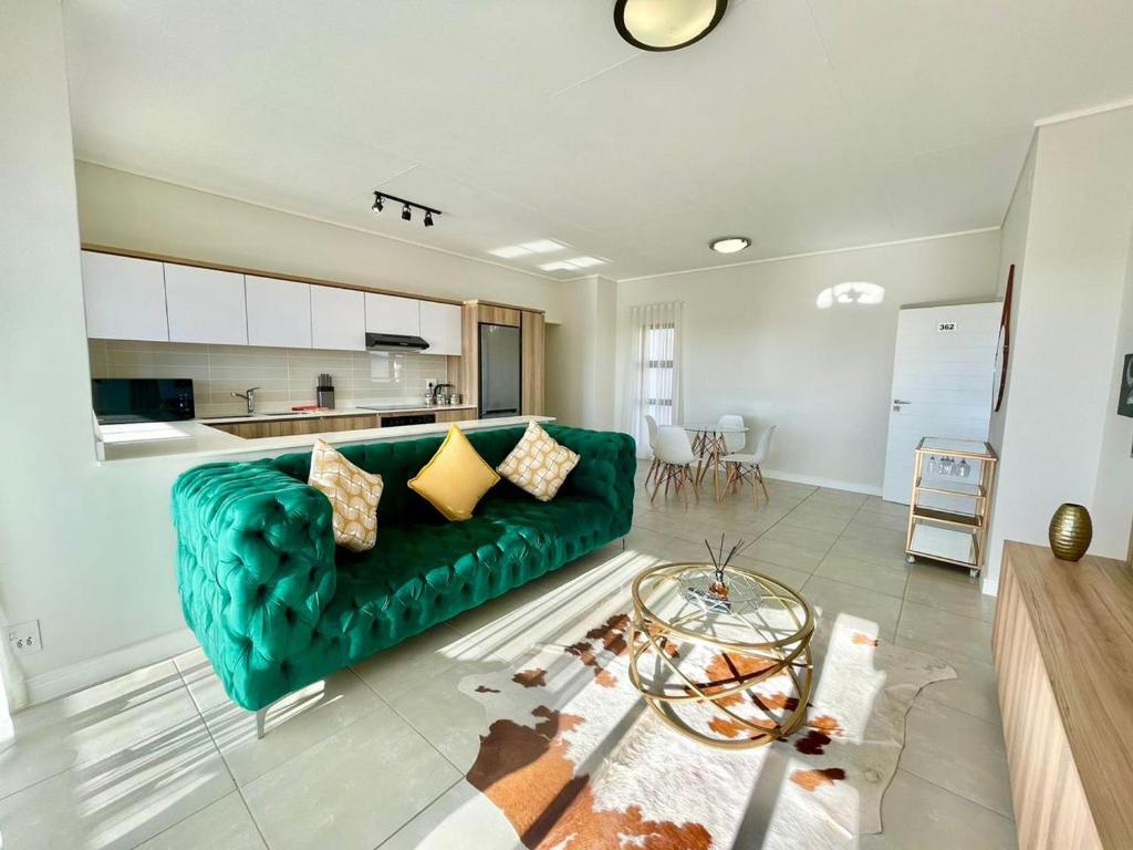 a living room with a green couch and a table at 362@BallitoHills in Ballito