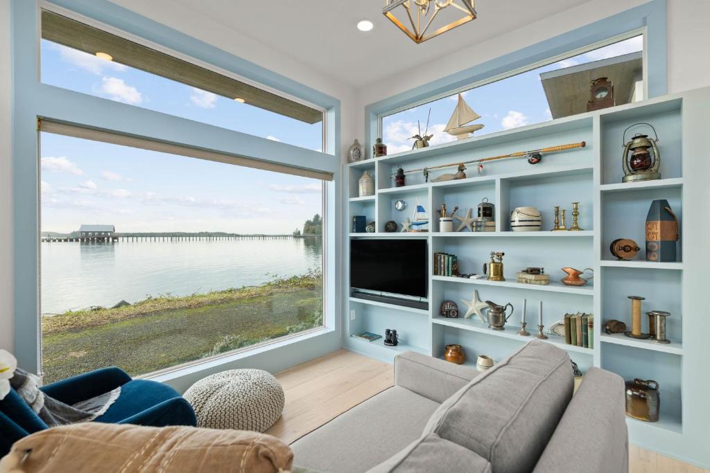 una sala de estar con una gran ventana con vistas al agua en Tillamook Bayfront Cottage - Amazing Views - Garibaldi, en Garibaldi