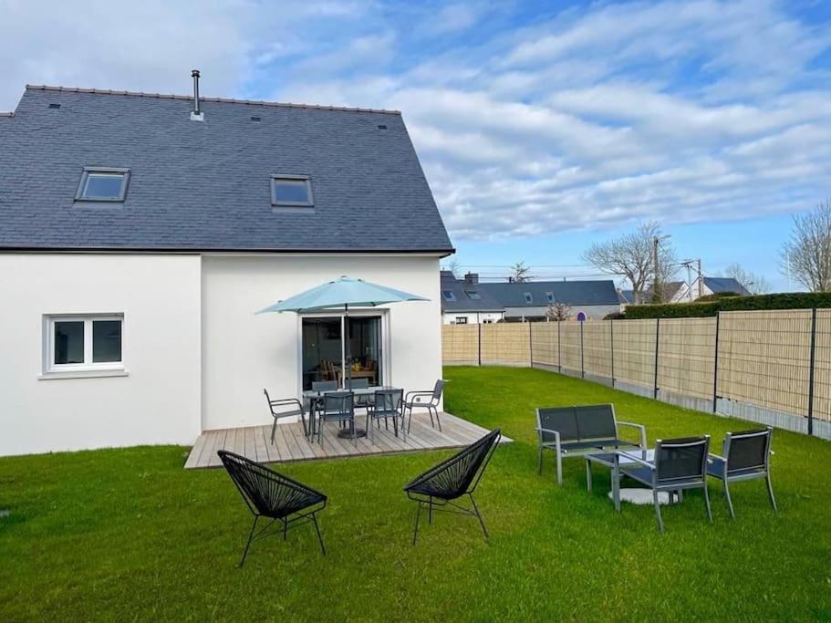 d'une terrasse avec des chaises, des tables et un parasol bleu. dans l'établissement Maison neuve à 5 mins des plages, à Erdeven