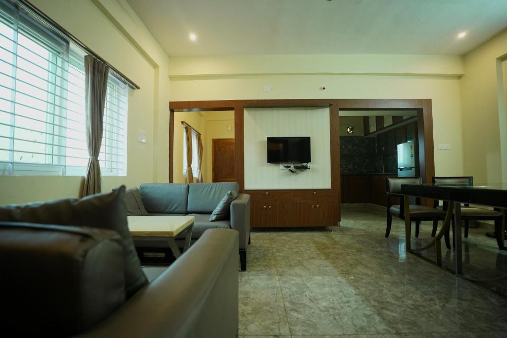 a living room with a couch and a table and a television at Sri Govindham Home Stay in Tirupati