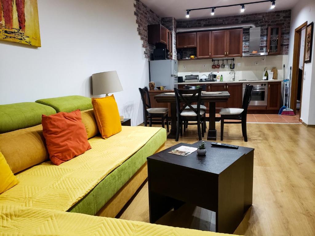 een woonkamer met een groene bank en een tafel bij Semiramida gardens Apartment 23 in Borovets