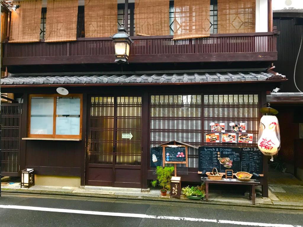 a building with a sign on the side of a street at Roman Kan in Kyoto