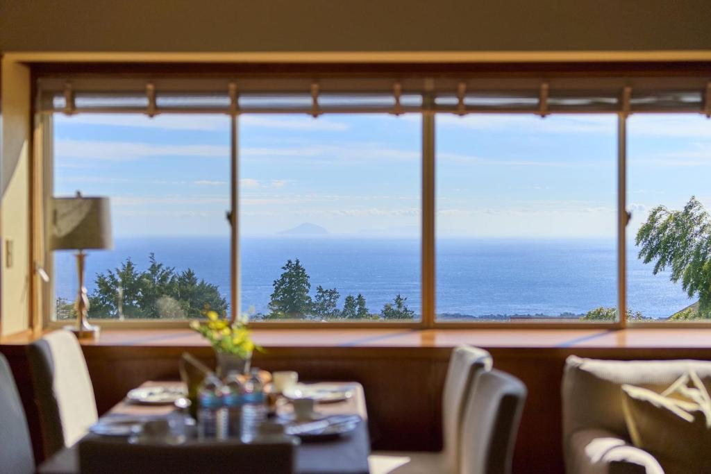 uma sala de jantar com vista para o oceano em スイートヴィラ伊豆高原オーシャンテラス em Futo