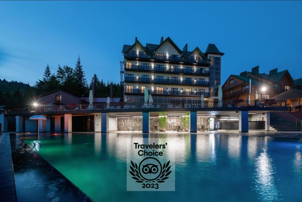 a hotel with a swimming pool in front of a building at Hotel Podgorie Spa in Bukovel