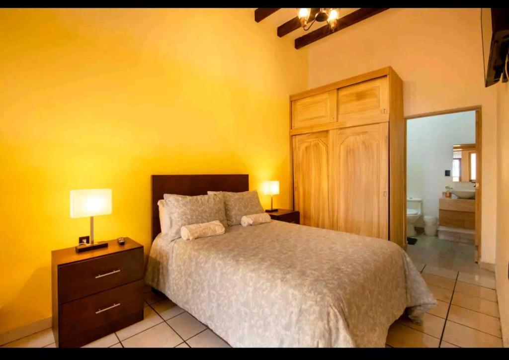 a bedroom with a bed and a dresser with two lamps at Room 3 for 2 People, Double Bed in Morelia