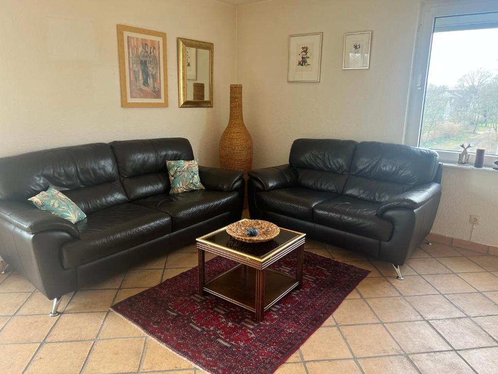a living room with black leather couches and a coffee table at Sehr große Wohnung nähe Düsseldorf, Flughafen und Messe in Duisburg