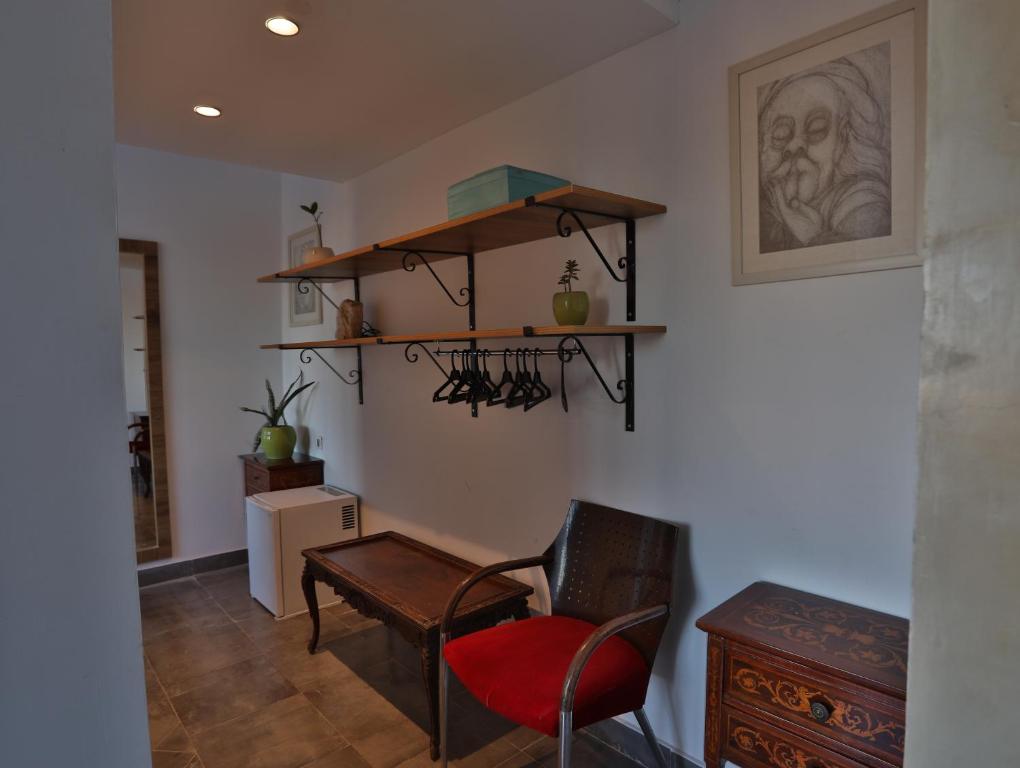 a room with a chair and a table and shelves at Dar Souad in La Marsa