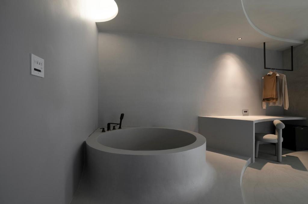 a white bathroom with a tub in a room at 山久蒔x勺光 in Yuchi