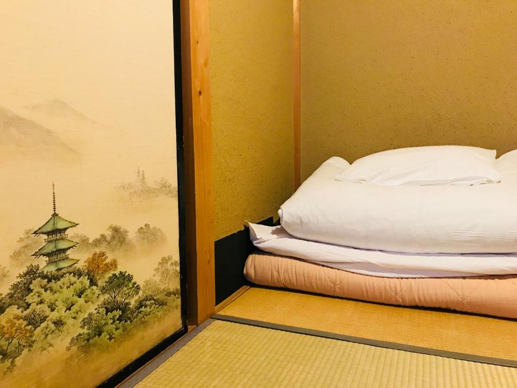 Łóżko lub łóżka w pokoju w obiekcie Nagomi-Ryokan Yuu