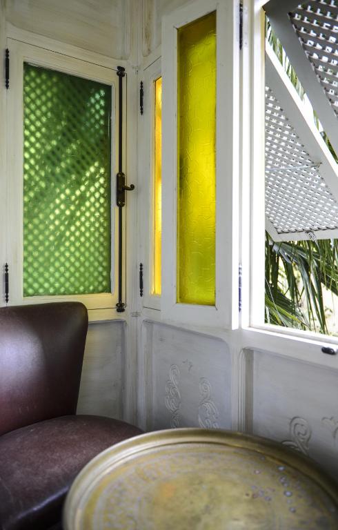 a room with two windows and a chair and a table at Dar Souad in La Marsa