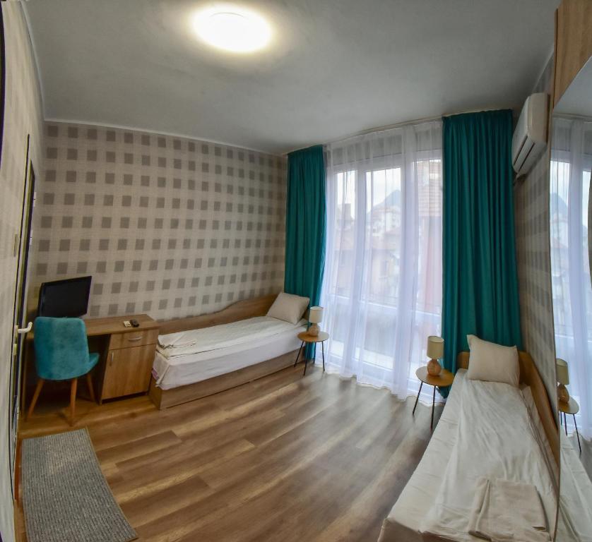 a room with a bed and a desk with a computer at Hotel Rade 1 in Vratsa