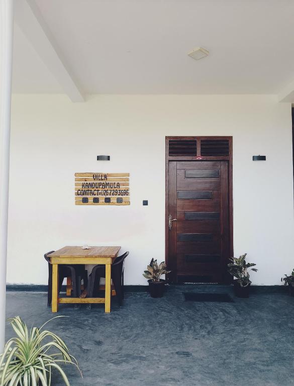 a wooden table in a room with a door at Villa kandupamula in Mirissa