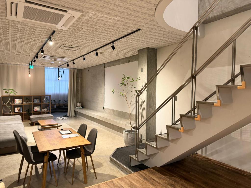 an office with a staircase and tables and chairs at Hotel art rock in Takamatsu