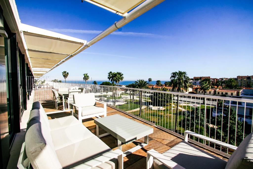 Elle comprend un balcon doté d'un mobilier blanc et offrant une vue sur l'océan. dans l'établissement Denia Beach - Ático en Primera Línea by Costablancarent Rentals, à Dénia