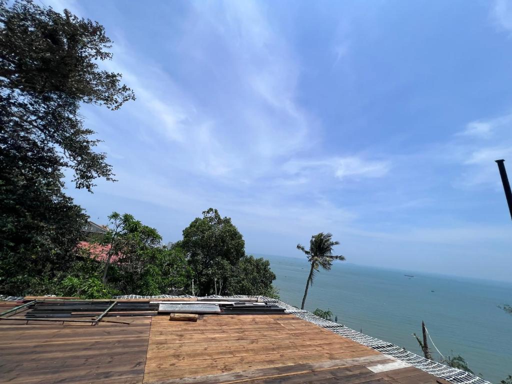 uma vista para a água a partir de um resort com uma palmeira em The mountain Sea View em Vung Tau