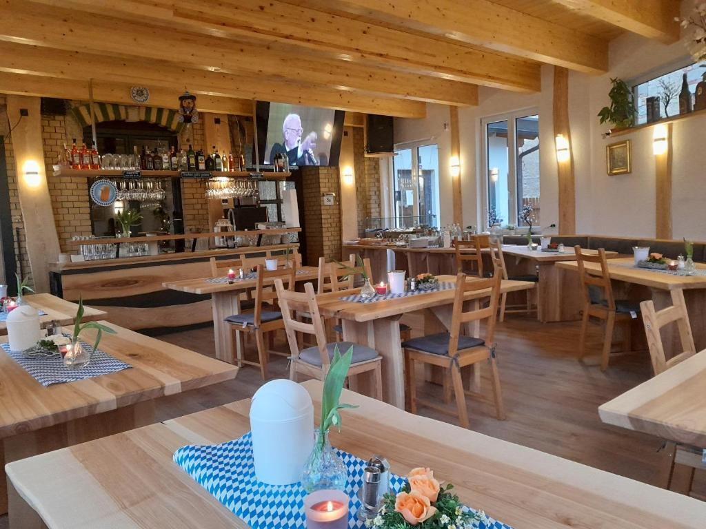 um restaurante com mesas e cadeiras de madeira e um bar em Ferienanlage Markus Nitsch em Bärenstein