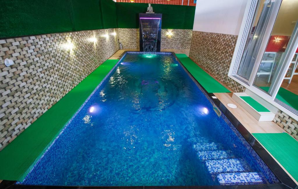 een binnenzwembad in een huis met een fontein bij PARADISE VILLA in Lonavala
