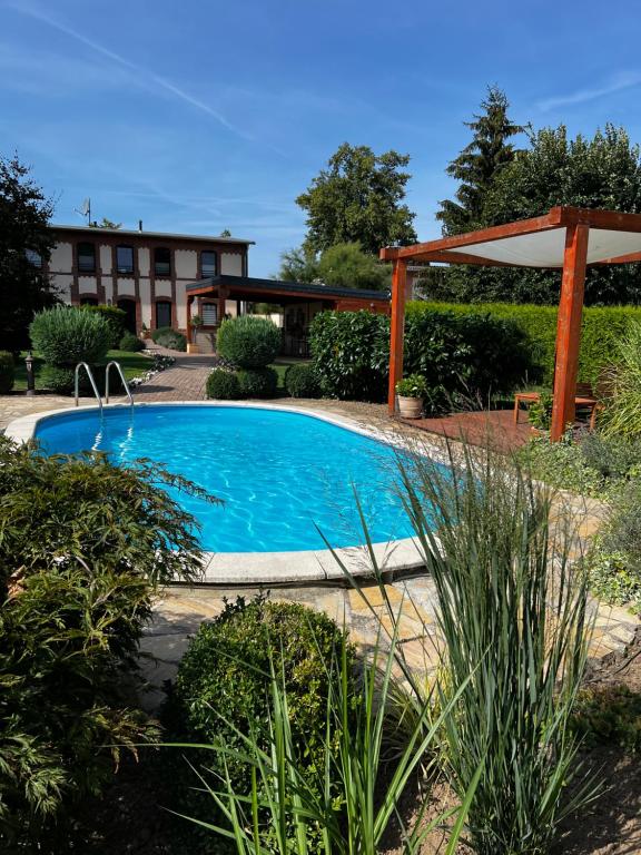 una piscina in un giardino con pergolato di Ferienwohnungen in der alten Schnitterkaserne a Prenzlau
