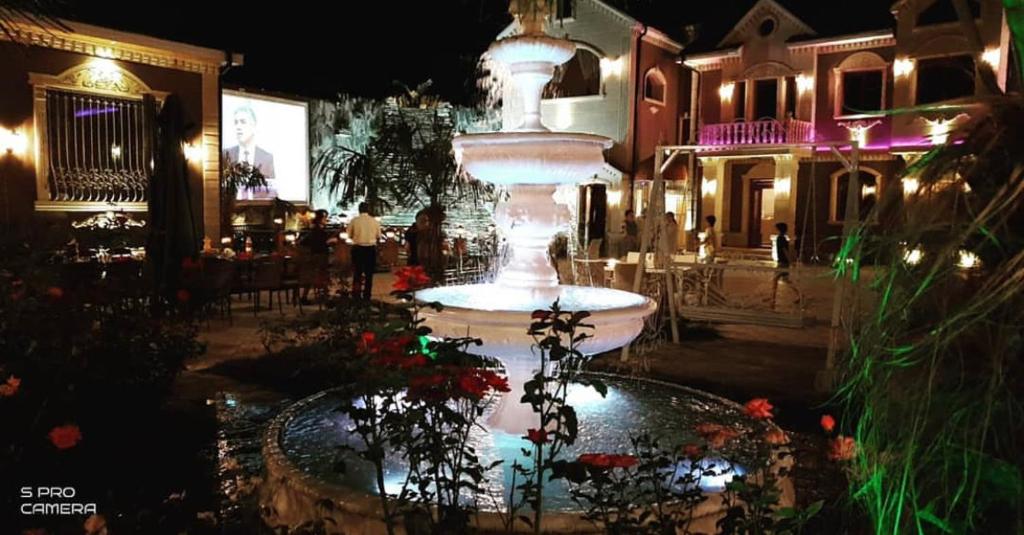 uma fonte em frente a um restaurante à noite em Museum Guest House-Muzey Ailəvi Qonaq Evi em Sheki
