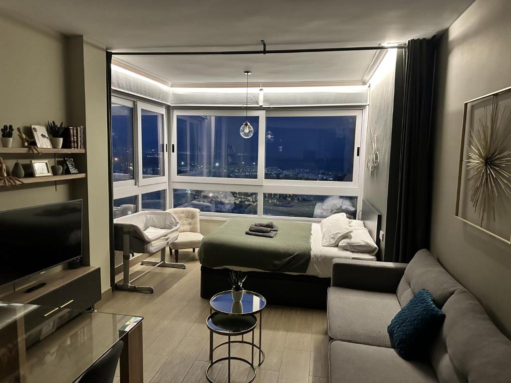 トレモリノスにあるSuite La Colinaのベッドルーム1室(ベッド1台付)、リビングルーム(窓付)が備わります。