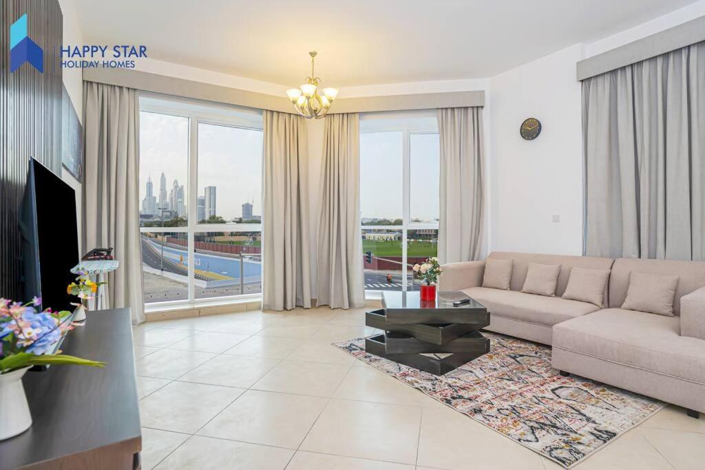 een woonkamer met een bank en een groot raam bij Luxurious 2BR Apartment near Palm Jumeirah in Dubai