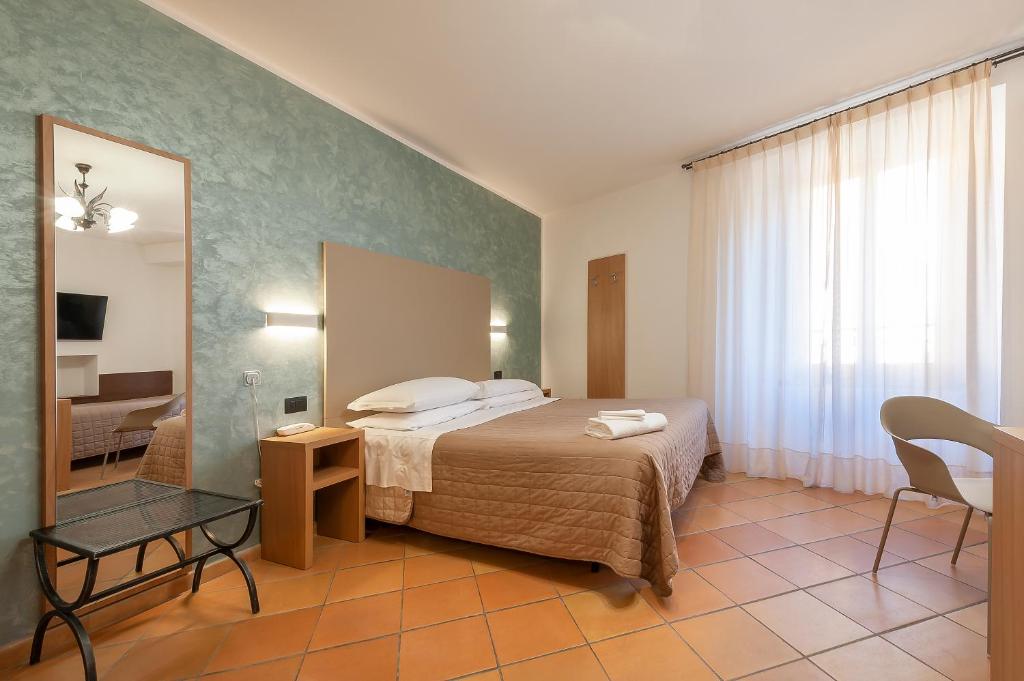 - une chambre d'hôtel avec un lit et un miroir dans l'établissement Hotel Sole, à Assise
