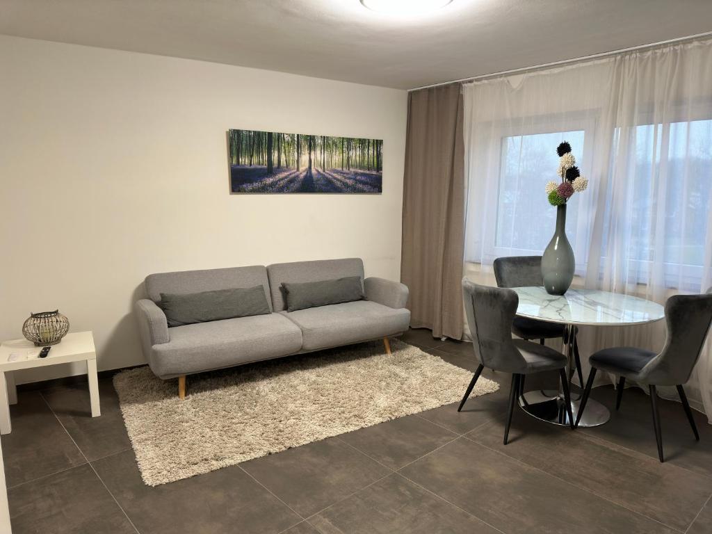een woonkamer met een bank en een tafel bij Moderne Ferienwohnung für 4 Personen im Herzen von Marl*Netflix*Nespresso* in Marl