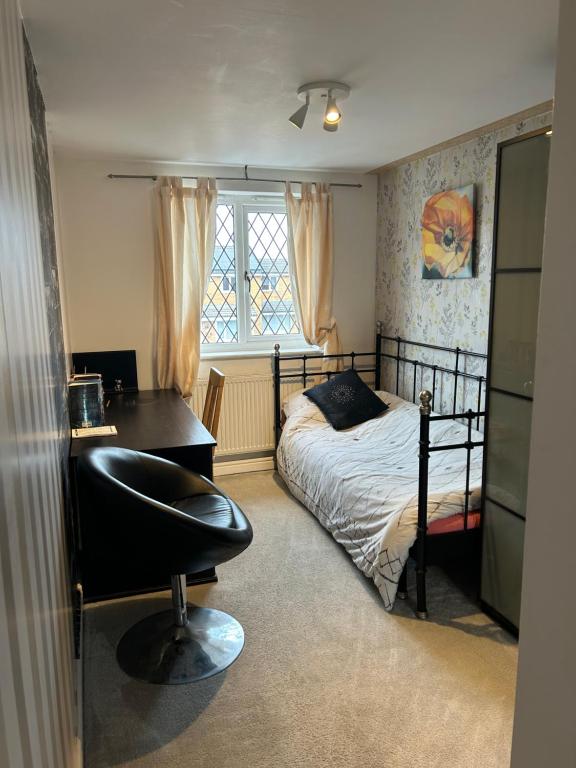 a bedroom with a bed and a desk and a chair at Spacious family home in Malins Lee