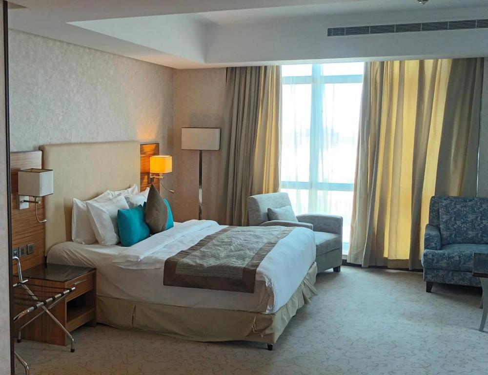 a hotel room with a bed and a chair at فندق الشهباء جده Al Shahba Jeddah in Jeddah