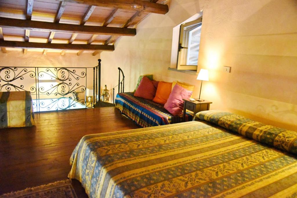 a bedroom with two beds and a couch at Vigna Di Valle in Bracciano