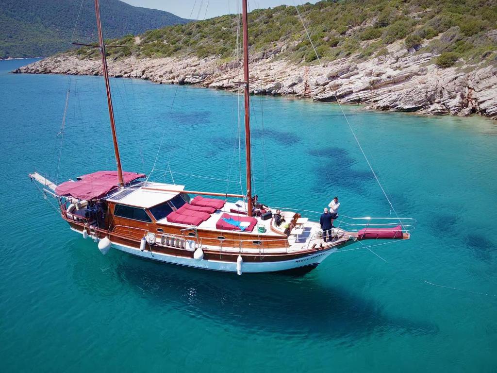 a man is standing on a sail boat in the water at Bodrum Private Boat Tours -Daily -Yacht Tours Bodrum in Bodrum City