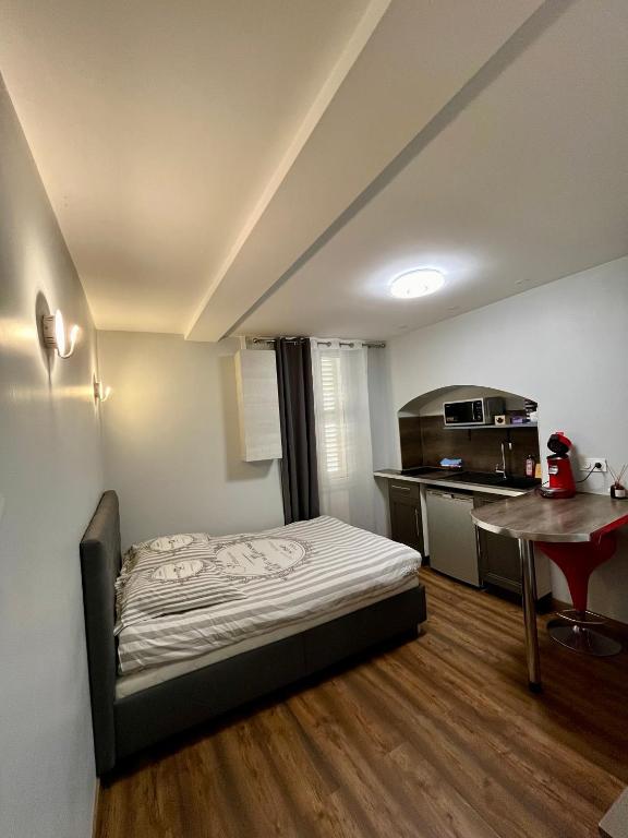 Cette petite chambre comprend un lit et une cuisine. dans l'établissement Charmant Studio au cœur historique de Fréjus, à Fréjus