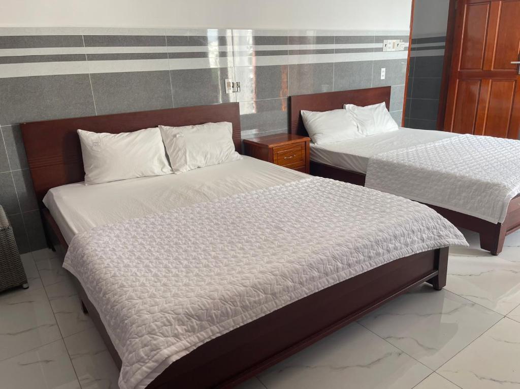 2 Betten in einem Hotelzimmer in der Unterkunft VIEW HOTEL- TRÀM CHIM in Tràm Chim