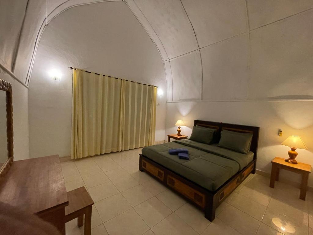 a bedroom with a bed with an arched ceiling at Rumah Tiga Gili in Gili Air