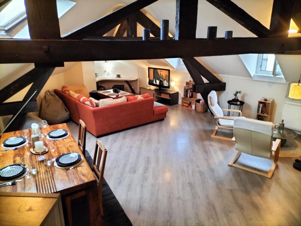 sala de estar con sofá rojo y mesa en Chambre(s) dans loft partagé, cosy et spacieux! en Tarbes