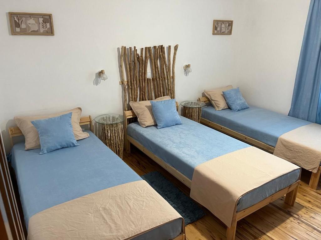 3 Betten in einem blau-weißen Zimmer in der Unterkunft Къща за гости Куклите Петревене in Petrevene