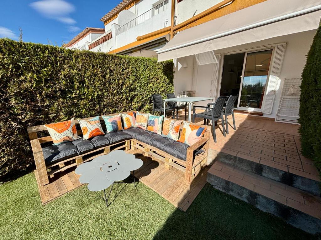 a patio with a couch and a table with chairs at Casas Plus Costa Brava in L'Estartit