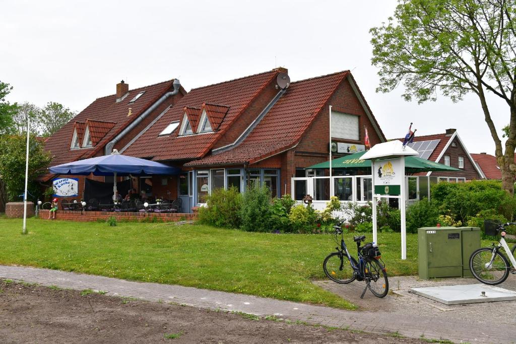 een huis met twee fietsen voor het huis bij Pension Restaurant Pizzeria Lion in Krummhörn