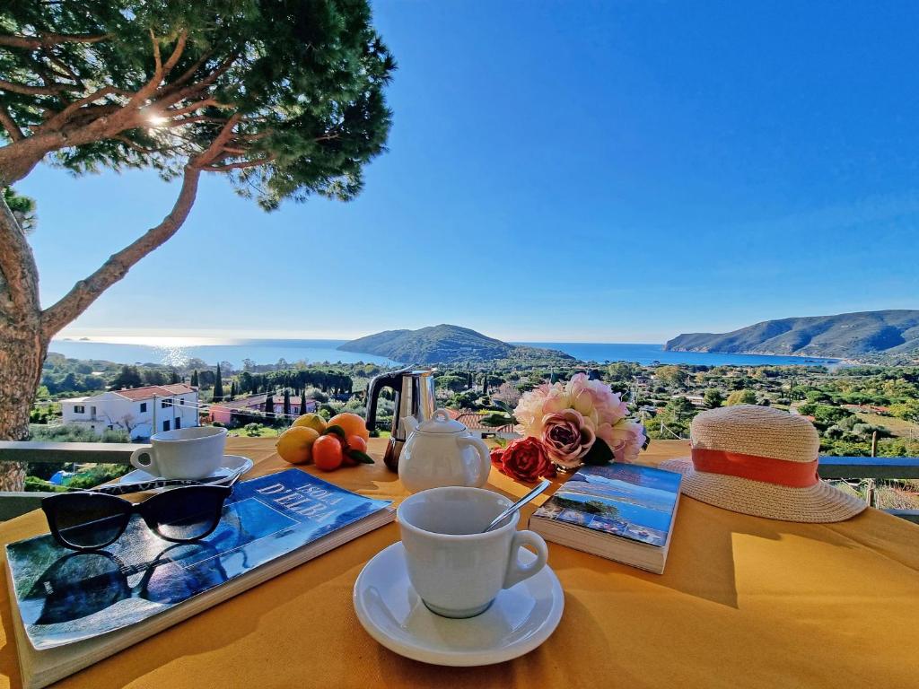 een tafel met een kopje koffie en glazen erop bij Residenza Mini Hotel - RTA e Appartamenti Vacanza in Lacona