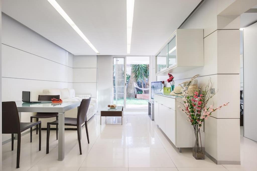 a kitchen and dining room with white cabinets and a table at Apartamento en la playa de Castelldefels ( Barcelona) in Castelldefels