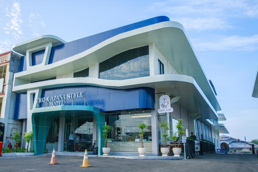 un edificio azul y blanco con conos delante en Two K Azana Style Hotel Bengkulu, en Bengkulu